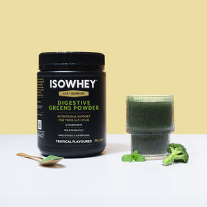 ISOWHEY Digestive Greens Powder container with a glass of powder and broccoli on a light yellow background