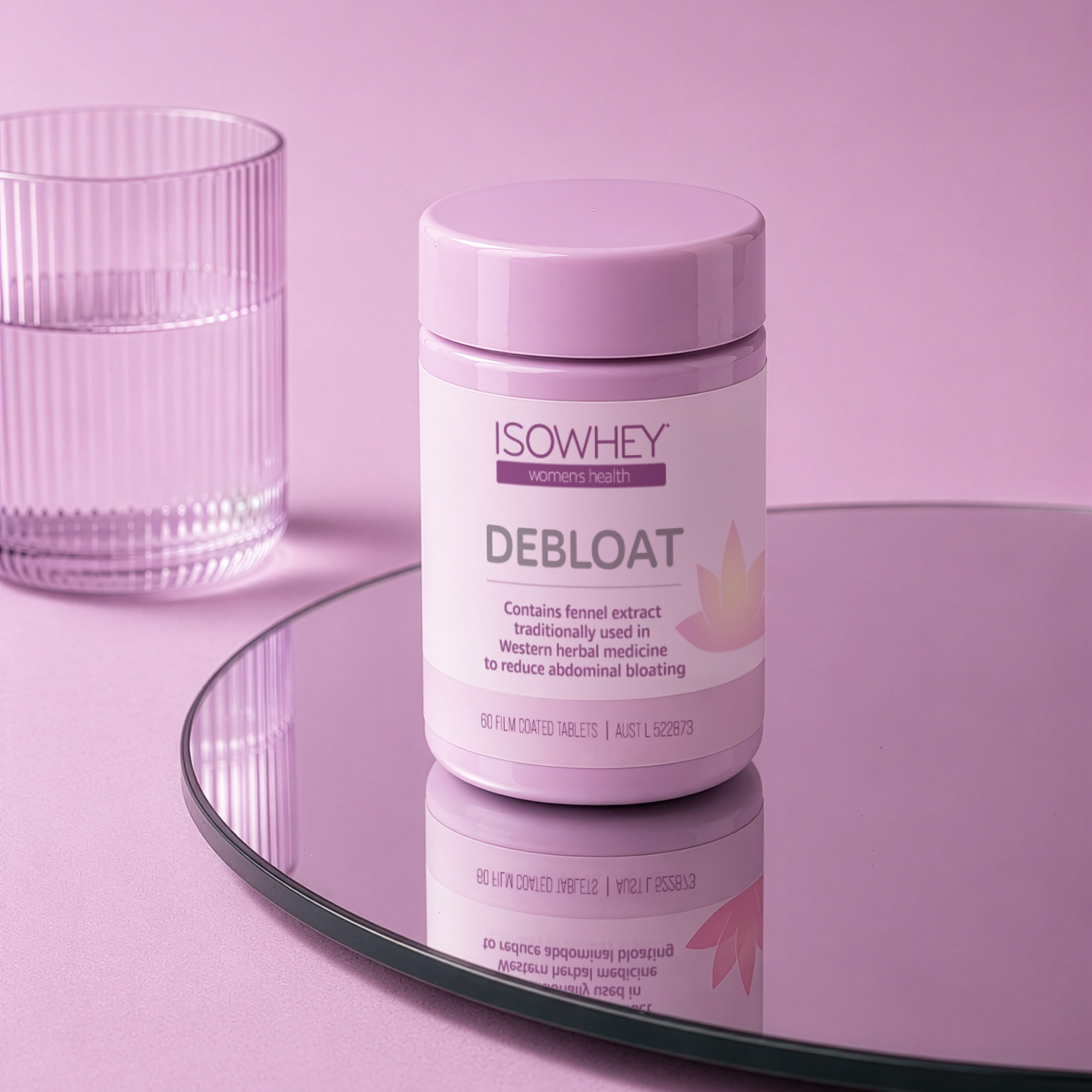 ISOWHEY Debloat supplement container on a pink surface with a glass of water.