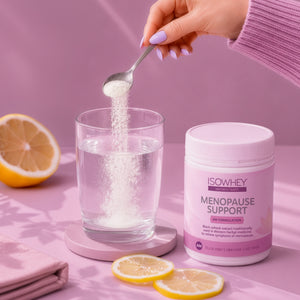 Person adding powder from a container labeled 'Menopause Support' into a glass of water with lemons on a pink background.